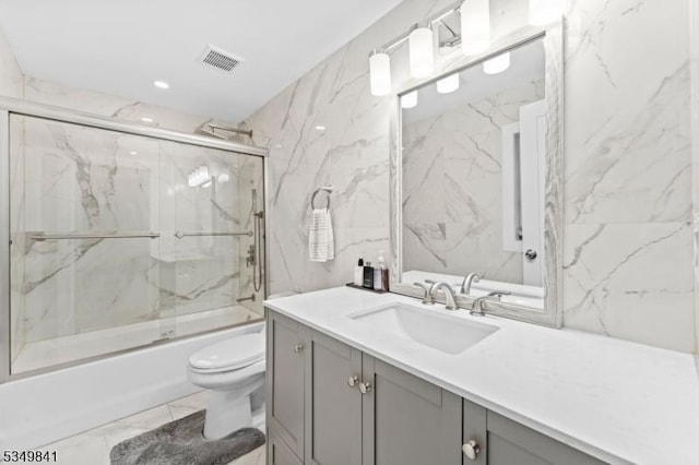 bathroom with combined bath / shower with glass door, vanity, toilet, visible vents, and marble finish floor