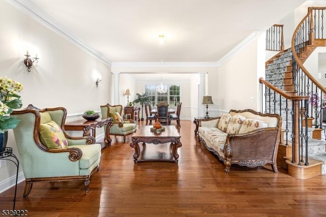 living room featuring a chandelier, wood finished floors, ornamental molding, and stairway