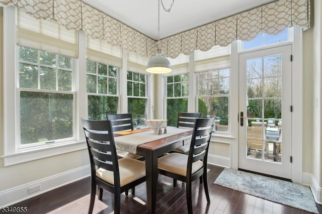 sunroom / solarium with baseboards, hardwood / wood-style flooring, and a healthy amount of sunlight