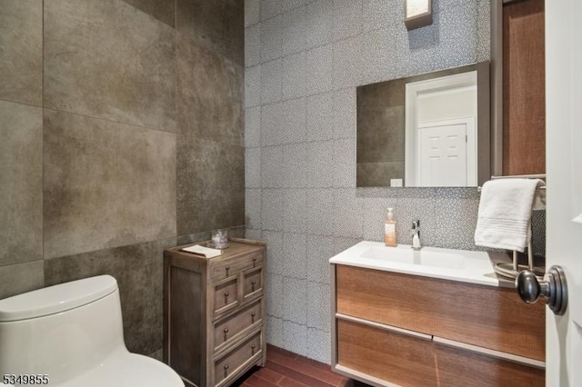 bathroom featuring tile walls, toilet, and vanity