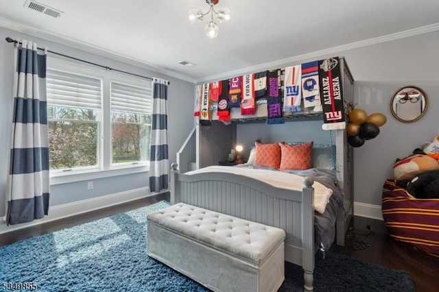 bedroom with visible vents, baseboards, ornamental molding, and wood finished floors