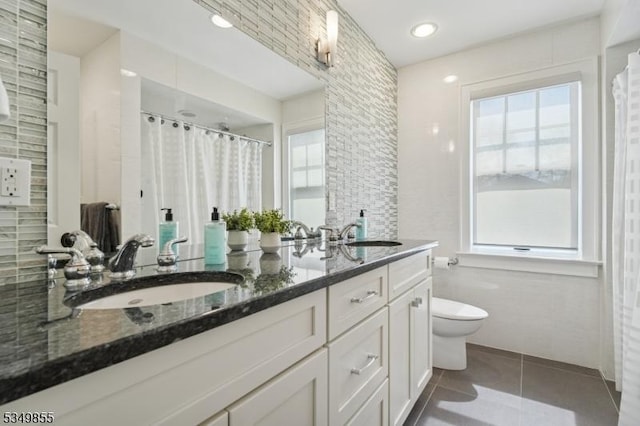 bathroom featuring a sink, tile patterned floors, toilet, and double vanity