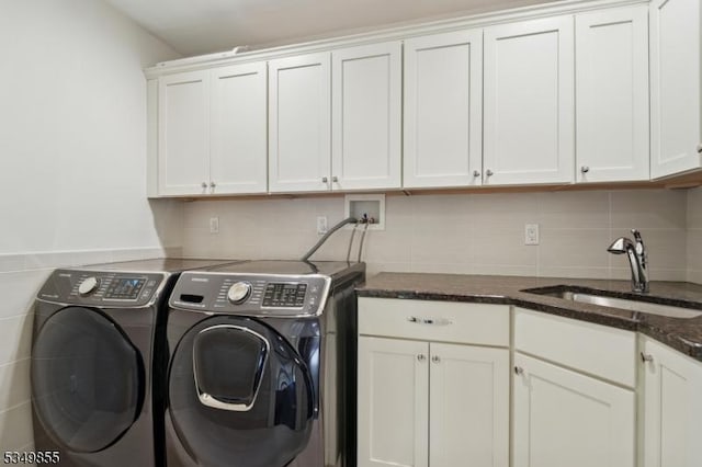 laundry room with separate washer and dryer, a sink, and cabinet space