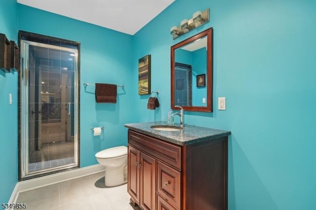full bathroom featuring vanity, baseboards, a stall shower, tile patterned flooring, and toilet