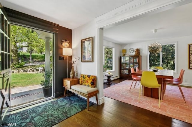 interior space with baseboards, wood finished floors, baseboard heating, and an inviting chandelier