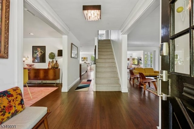 foyer featuring baseboards, wood finished floors, and stairway