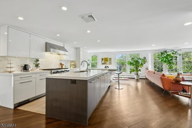kitchen featuring white cabinetry, visible vents, modern cabinets, and wall chimney exhaust hood
