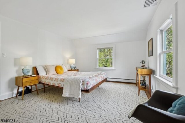 bedroom featuring a baseboard heating unit and visible vents