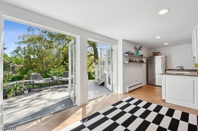 doorway with a sink, light tile patterned floors, a baseboard heating unit, and recessed lighting