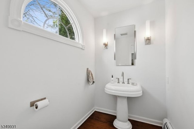 bathroom featuring baseboards, baseboard heating, and wood finished floors