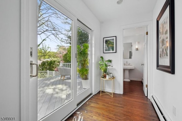 entryway with baseboards, wood finished floors, and a baseboard radiator