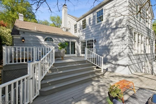 rear view of property with stairway and a deck