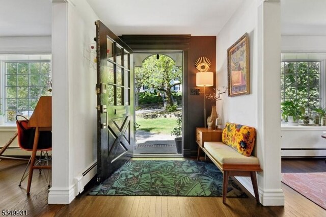 doorway to outside featuring baseboards, a baseboard radiator, baseboard heating, and hardwood / wood-style floors