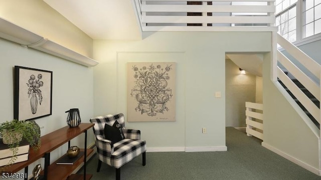living area with baseboards, an upstairs landing, and carpet flooring