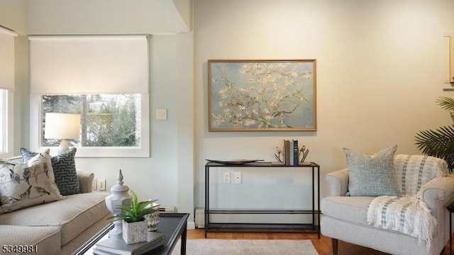 living area with baseboard heating and wood finished floors