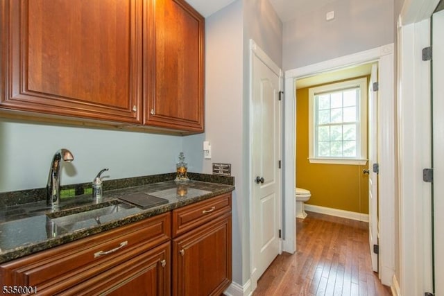 8 Marcin Way, Mount Olive Twp, NJ 07836 - kitchen featuring a sink, light wood finished floors, dark stone counters, baseboards, and brown cabinetry