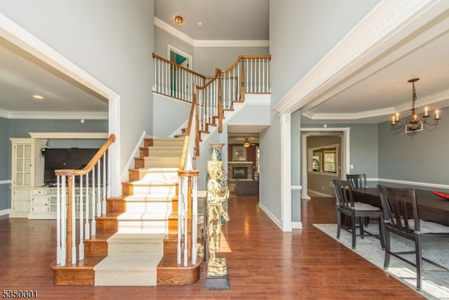 8 Marcin Way, Mount Olive Twp, NJ 07836 - stairway featuring a fireplace, wood finished floors, crown molding, a chandelier, and baseboards