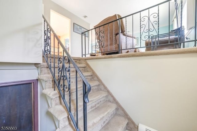 staircase with a baseboard heating unit