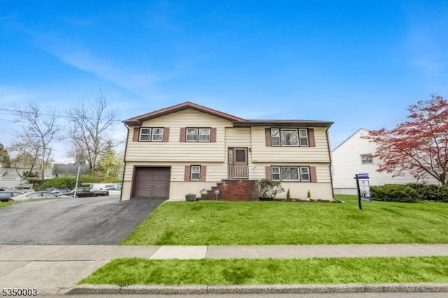 bi-level home featuring a front yard, asphalt driveway, and an attached garage
