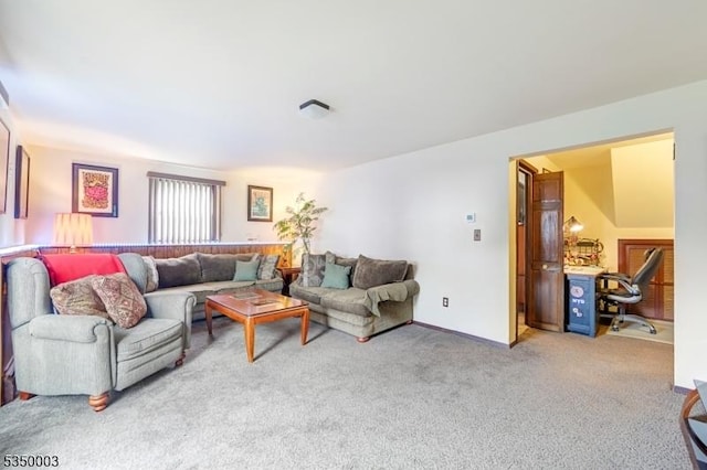 living area featuring carpet flooring, a desk, and baseboards