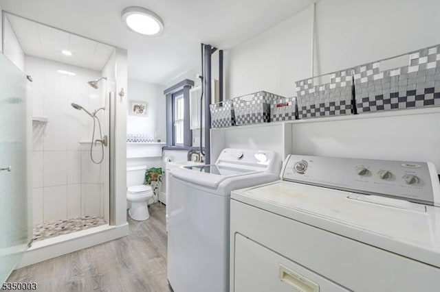 laundry area with light wood-style floors and washer and dryer