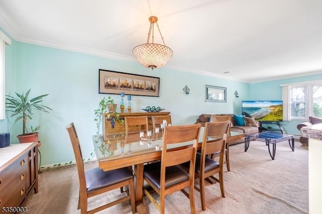 dining room with light colored carpet, ornamental molding, and baseboards