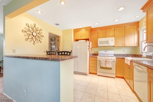 kitchen featuring white appliances, a sink, a peninsula, light tile patterned flooring, and recessed lighting