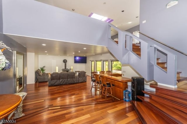 155 Route560, Sandyston Twp, NJ 07851 - living room featuring wood finished floors, stairs, a wood stove, and a towering ceiling