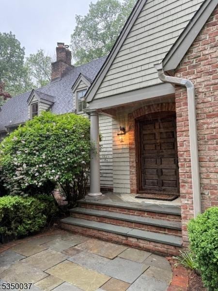 9 Valley View Dr, Lebanon Twp, NJ 07830 - entrance to property featuring a chimney, brick siding, and roof with shingles