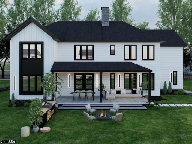 back of house featuring a yard, a shingled roof, and a chimney