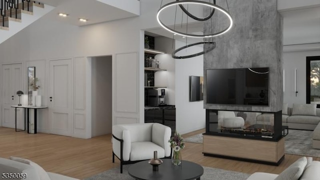 living room with stairway, a high ceiling, and wood finished floors