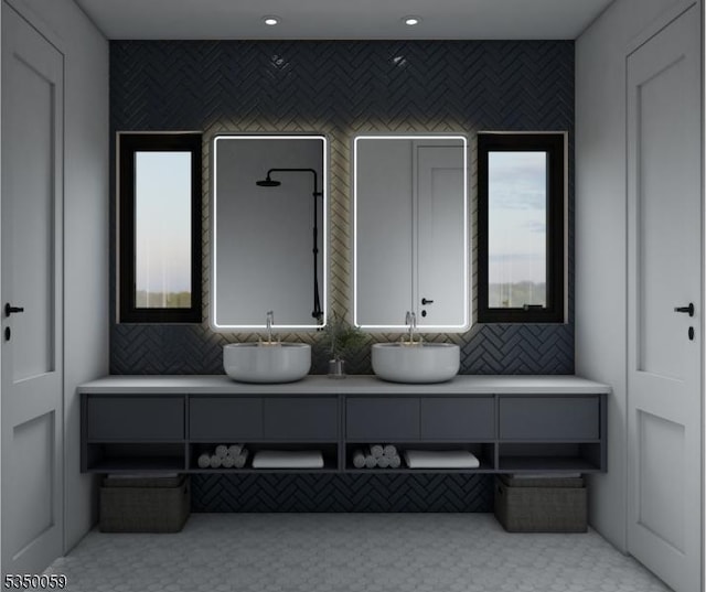 bathroom with a sink, double vanity, and a healthy amount of sunlight