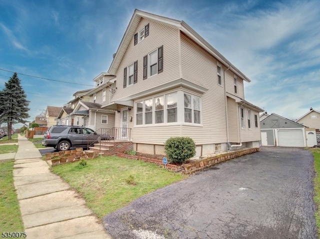 view of front facade with a front lawn, a garage, and an outdoor structure