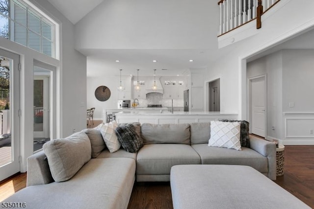 living area with recessed lighting, high vaulted ceiling, and dark wood-type flooring
