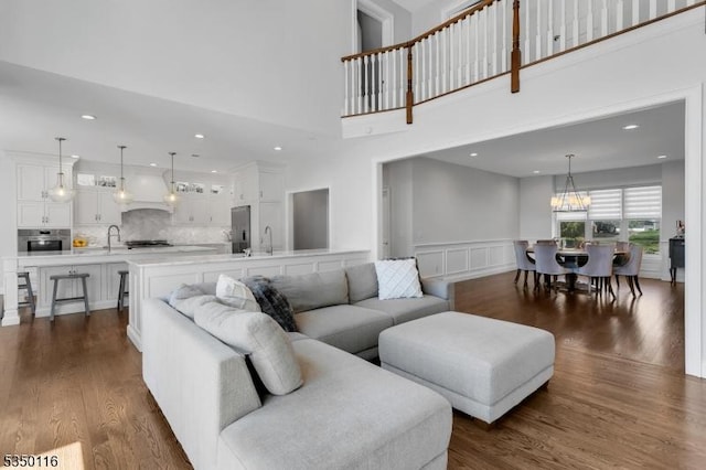living area with recessed lighting, a wainscoted wall, and dark wood-style floors