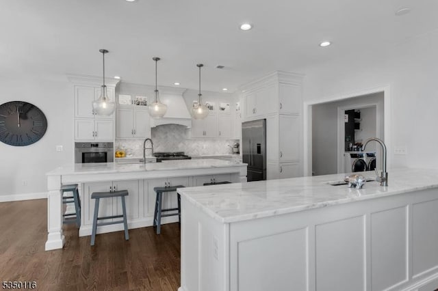 kitchen featuring a sink, decorative backsplash, white cabinets, and stainless steel appliances
