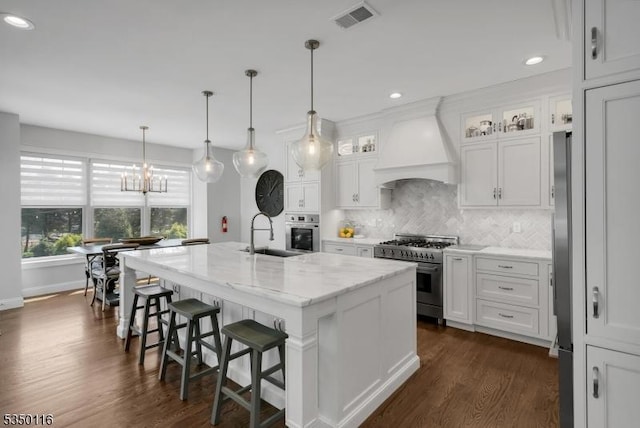 kitchen featuring dark wood-style flooring, white cabinetry, appliances with stainless steel finishes, and custom exhaust hood