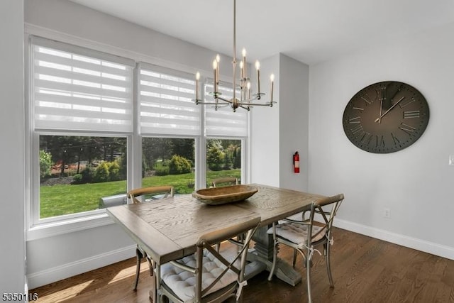 dining space featuring baseboards, a chandelier, and dark wood-style floors