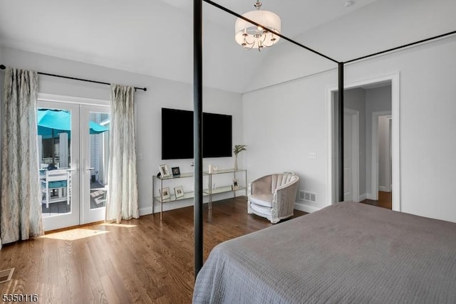 bedroom featuring visible vents, wood finished floors, lofted ceiling, access to exterior, and french doors