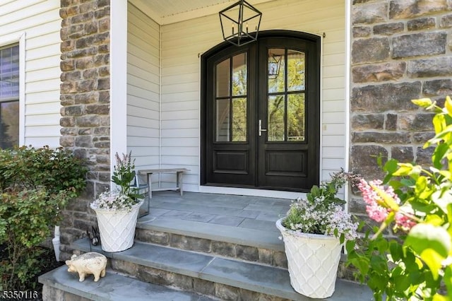 entrance to property featuring a porch and french doors