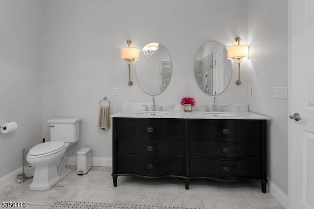 bathroom featuring double vanity, toilet, baseboards, and a sink