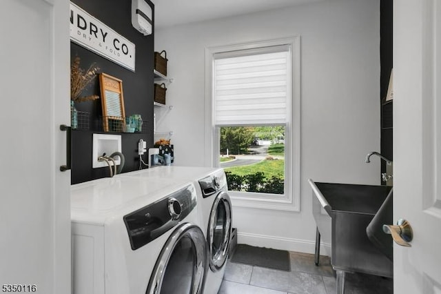 laundry room with laundry area, washing machine and dryer, baseboards, and tile patterned flooring