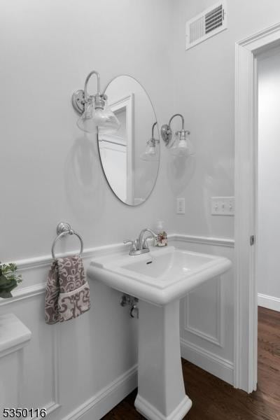 bathroom with baseboards, wood finished floors, and visible vents