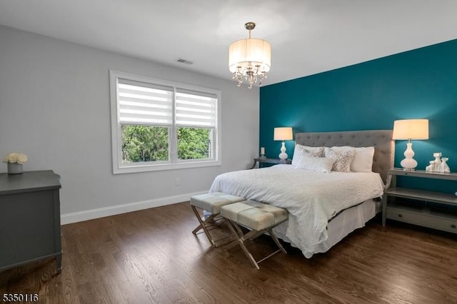 bedroom with an inviting chandelier, baseboards, dark wood finished floors, and visible vents