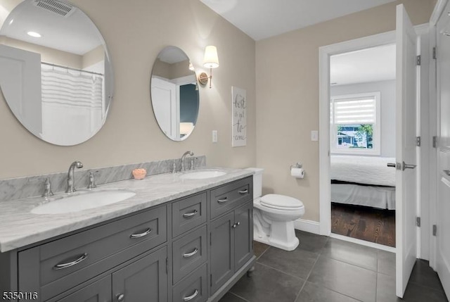 bathroom with a sink, tile patterned floors, double vanity, and visible vents