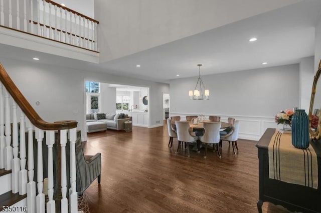 dining room with a wainscoted wall, an inviting chandelier, a decorative wall, recessed lighting, and dark wood-type flooring