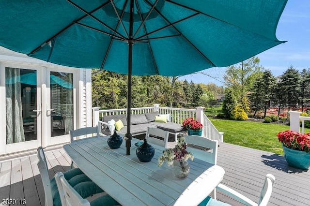 wooden terrace featuring a lawn and outdoor lounge area