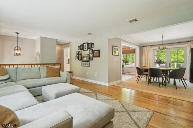 15 Longhill Rd, Randolph Twp, NJ 07869 - living room with baseboards, light wood-type flooring, a chandelier, and a baseboard heating unit