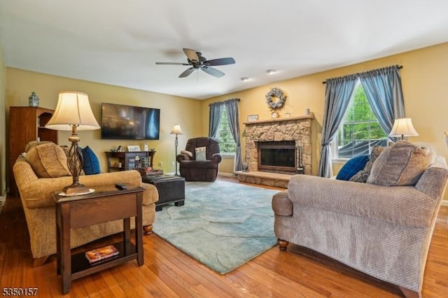 living area with ceiling fan, wood finished floors, and a fireplace
