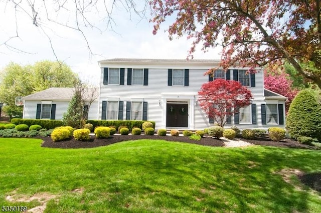colonial house featuring a front lawn